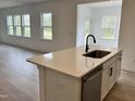 Kitchen island with stainless steel dishwasher, sleek faucet and sink, quartz countertops, and modern white cabinets at 1140 Sun Springs Rd, Wake Forest, NC 27587