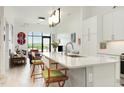 Bright open kitchen with modern lighting, white cabinetry, and views to the living area at 120 Mosaic Blvd # 308, Pittsboro, NC 27312