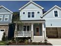 Beautiful two-story home with light blue siding, front porch, and manicured front yard under a clear blue sky at 1237 Porters Call Dr, Wendell, NC 27591