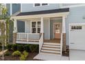 Inviting front porch with a pink front door, white railings, and a view of the landscaped yard at 1237 Porters Call Dr, Wendell, NC 27591