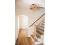 Bright foyer features wood staircase, light fixture, and arched doorway leading to light filled rooms at 1326 Apache Ln, Apex, NC 27502