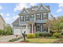 Charming two-story home boasts a red door, three-car garage, and professionally landscaped front yard at 200 Windy Knoll Cir, Chapel Hill, NC 27516