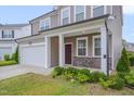 Inviting home exterior featuring a covered front porch with stone accents and a well-maintained lawn at 205 Loxton St, Fuquay Varina, NC 27526