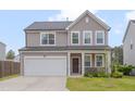 Charming two-story home with a two-car garage, stone accents, and a well-manicured lawn at 205 Loxton St, Fuquay Varina, NC 27526