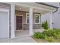 Covered front porch showcasing stone accents, white columns, and a well-kept lawn at 205 Loxton St, Fuquay Varina, NC 27526