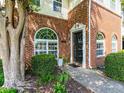 Close-up of townhouse entrance with brick facade, arched windows, and well-manicured landscaping at 2101 Piney Brook Rd # 105, Raleigh, NC 27614