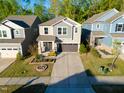 Beautiful two-story home with a well-manicured lawn, mature trees, and a two-car garage at 2123 Gregor Overlook Ln, Apex, NC 27502