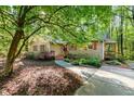 Beautiful exterior of a one-story house with a stone walkway and driveway, surrounded by lush greenery and trees at 3217 Brennan Dr, Raleigh, NC 27613