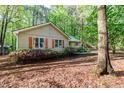 Exterior view of home with colorful flowerbeds at the front and mature trees surrounding the property at 3217 Brennan Dr, Raleigh, NC 27613