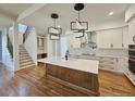 Modern kitchen featuring hardwood floors, an island, white cabinets, stainless steel appliances, and pendant lighting at 35 Big Bear Dr, Pittsboro, NC 27312