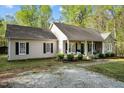 A cozy, single-story home with tan siding, dark shutters, and a charming front porch at 359 Punch Hill Farm Rd, Rougemont, NC 27572