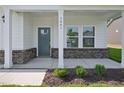 Inviting front porch with decorative columns and brick accents and address number displayed at 3841 Rosebush Dr, Zebulon, NC 27597