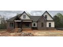 Newly built home showcasing a brick and siding exterior with dark trim accents, and a covered front porch and sidewalk at 3920 Cedar Knolls Drive Dr # 18, Youngsville, NC 27596