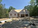 Framing of a new home with wood stacked on the lot, featuring a sunny, wooded background at 42 Ponchartrain St, Fuquay Varina, NC 27526