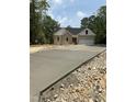 New construction features stone and vinyl siding, a two-car garage and a long concrete driveway at 42 Ponchartrain St, Fuquay Varina, NC 27526