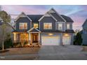 Charming two-story home with a three car garage illuminated with exterior lighting at 437 Creekhurst Pl, Cary, NC 27519