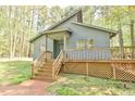 Charming gray home featuring a covered porch and wooden steps leading to the front door, surrounded by nature at 505 Marion Way, Chapel Hill, NC 27516