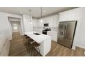 Modern kitchen with white cabinets, stainless steel appliances, and a large island with bar seating at 520 Folk Song Way, Wendell, NC 27591