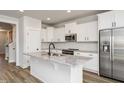 Modern kitchen featuring an island with granite countertops, stainless steel appliances, and white cabinetry at 520 Folk Song Way, Wendell, NC 27591
