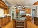 Gourmet kitchen with granite countertops, stainless steel appliances, and custom wood cabinetry at 5768 Cavanaugh Dr, Raleigh, NC 27614