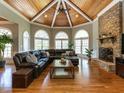 Cozy living room with a stone fireplace, vaulted wood ceiling, and lots of natural light at 5768 Cavanaugh Dr, Raleigh, NC 27614