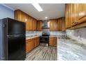 Updated kitchen boasts wood cabinets, stainless steel appliances, and marble countertops and backsplash at 6 Hawaii Ct, Durham, NC 27713