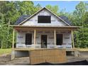 Exterior view of home under construction, showing framing and structure with porch and forested background at 608 Hemlock Ave, Durham, NC 27707