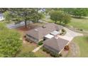 Aerial view of a stone home with a lush, landscaped yard and a winding driveway at 609 W Main St, Benson, NC 27504