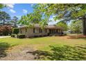 Beautiful stone home featuring a well-manicured lawn with decorative shrubbery at 609 W Main St, Benson, NC 27504