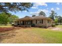 This inviting stone home is surrounded by verdant lawn and ornamental plantings at 609 W Main St, Benson, NC 27504
