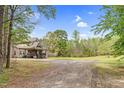 Property with spacious driveway and charming curb appeal, enhanced by lush landscaping, creating a welcoming atmosphere at 93 Clifton Pond Rd, Louisburg, NC 27549