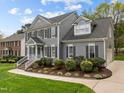 Charming gray home with manicured landscaping, brick steps and black shutters at 104 Dallavia Ct, Morrisville, NC 27560