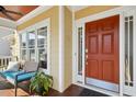 Inviting covered front porch featuring a red front door, bench seating, and decorative foliage at 109 Homegate Cir, Apex, NC 27502