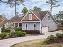 View of the home showcasing the garage, driveway, and manicured landscaping along the side of the house at 110 Streamside Dr, Sanford, NC 27330