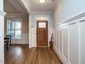 Bright foyer featuring a wooden front door, beautiful floors, and elegant wainscoting at 110 Streamside Dr, Sanford, NC 27330