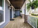 Inviting covered porch with stone columns, hanging ferns, and rocking chairs, perfect for outdoor relaxation at 110 Streamside Dr, Sanford, NC 27330