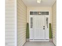 Inviting front entrance with a classic white door, sidelights and decorative potted plants at 1112 Addington Lake Ln, Knightdale, NC 27545