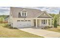 Beautiful home featuring a two-car garage, manicured lawn and covered front porch with seating at 1112 Addington Lake Ln, Knightdale, NC 27545