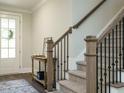Interior view of a staircase with dark metal railing, carpeted steps and a light wood banister at 113 Tower Ridge Ln, Sanford, NC 27330
