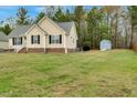 Expansive backyard view of home with a storage shed and mature trees, perfect for outdoor activities at 114 Carriage Hill Dr, Stem, NC 27581
