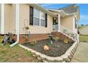 Attractive home exterior with brick accents, flower beds, and landscaped front entrance at 114 Carriage Hill Dr, Stem, NC 27581