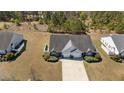 Aerial view of a well-maintained home with a spacious lawn, driveway, and lush surrounding greenery at 123 Ariel St, Lillington, NC 27546