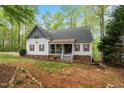 Charming two-story home featuring red shutters, covered porch and lush, mature landscaping at 147 W Alex Dr, Clayton, NC 27520