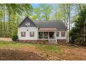Charming two-story home featuring red shutters, covered porch and lush, mature landscaping at 147 W Alex Dr, Clayton, NC 27520