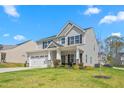 Charming two-story home on a lush lawn, featuring an attached garage and covered porch at 1725 Langlais Dr, Graham, NC 27253
