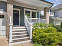 View of the front porch with white railings and wooden stairs, complemented by lush greenery at 173 Hawk Point Rd, Chapel Hill, NC 27516