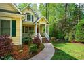 Welcoming walkway leading to a charming front porch with beautifully landscaped surroundings in a wooded setting at 18 Green Ridge Ln, Pittsboro, NC 27312