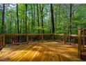 Spacious wooden deck featuring decorative wood railings overlooking lush greenery and mature trees for outdoor living at 18 Green Ridge Ln, Pittsboro, NC 27312