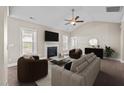 Cozy living room with a fireplace, ceiling fan, plenty of natural light, and comfortable seating at 205 Mcclellan Trl, Mebane, NC 27302