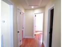 Hallway featuring hardwood flooring and multiple doorways leading to various rooms at 2117 Wrenn St, Burlington, NC 27215